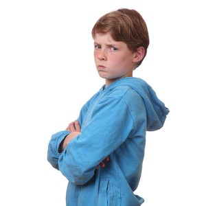 Portrait of an angry young boy on white background